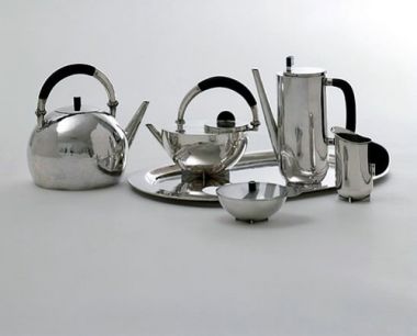 玛丽安·勃兰特(Marianne Brandt)的茶具:一种六件套的茶壶，用闪亮的银色金属装饰。