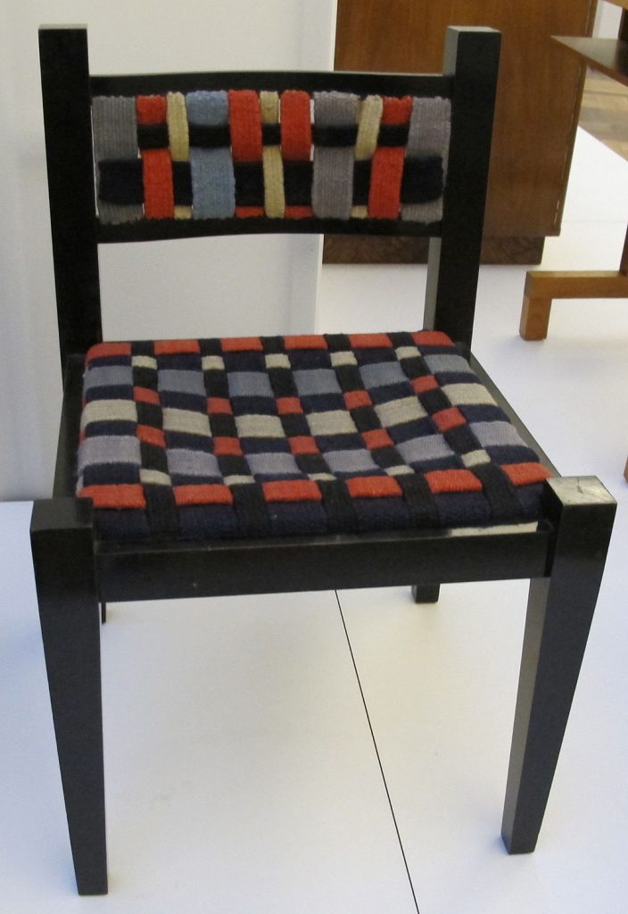 Gunta Stölzl Marcel Breuer椅子上的纺织品(1922):带有深色木腿的格子软垫椅子。