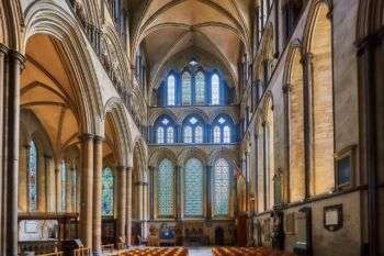 英格兰索尔兹伯里一座大教堂的东端。墙壁上覆盖着华丽的拱形窗户，分为3行。此外，在整个大教堂的窗户两侧都可以看到拱门。